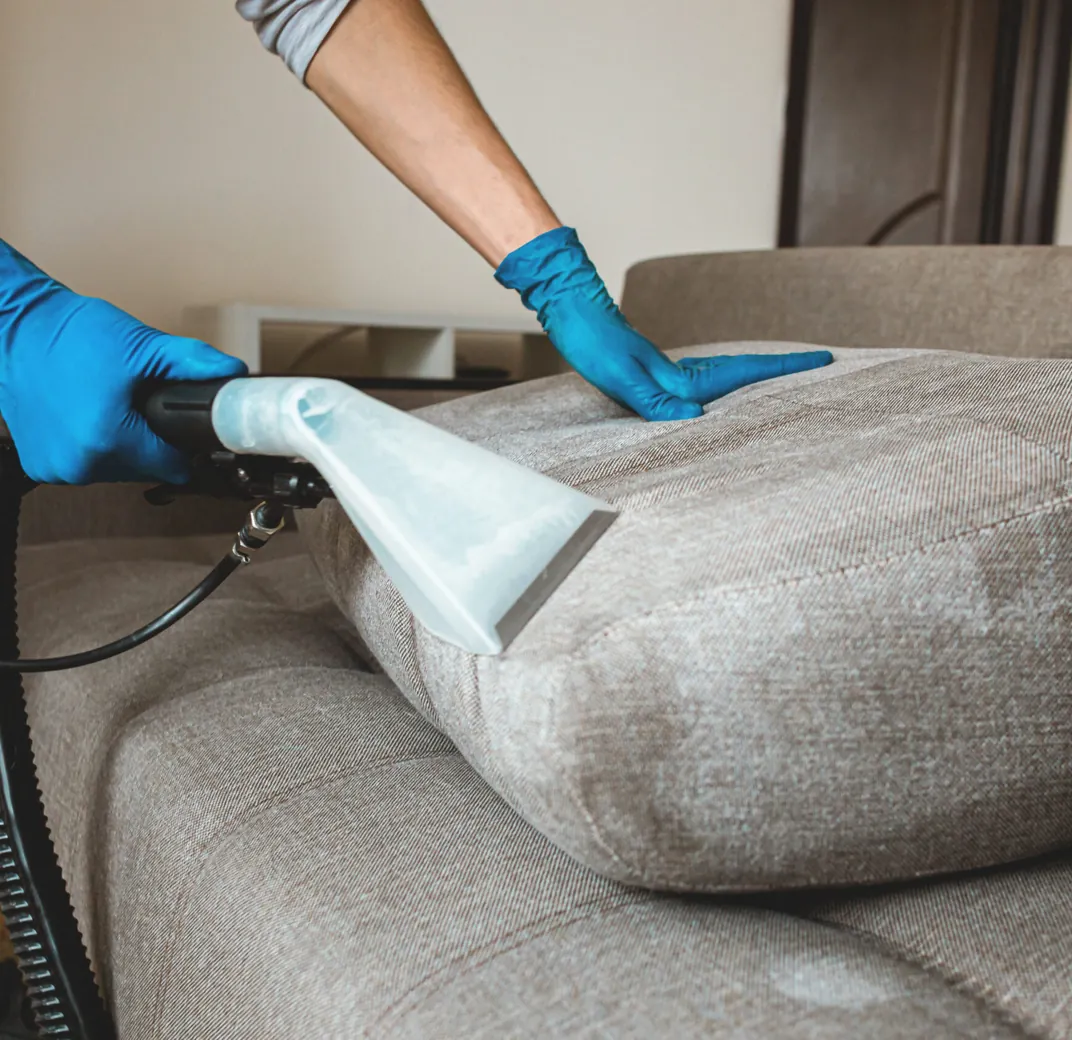 Upholstery extraction tool cleaning a sofa cushion